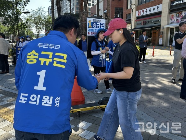횡단보도를 건너는 시민에게 고개 숙여 인사하는 송규근 경기도의원 후보.