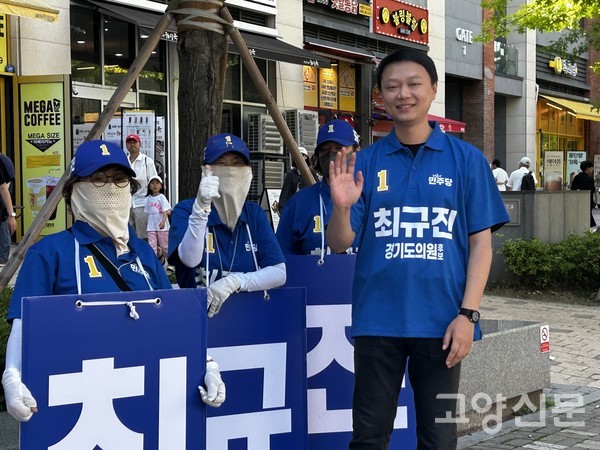 파란색 유니폼을 맞춰 입은 선거운동원들과 손을 흔들며 유세 현장에서 파이팅을 외치는 최규진 경기도의원 후보.