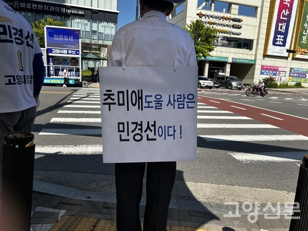 한 시민이 등 뒤에 '추미애 도울 사람은 민경선이다!'라는 문구를 부착하고 묵묵히 자리를 지키며 독특한 방식으로 민 후보를 응원하고 있다.