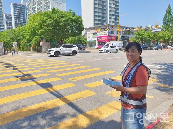 청소년지도위원회 조끼를 입고 홍보물을 돌리고 있는 이재수 회장.