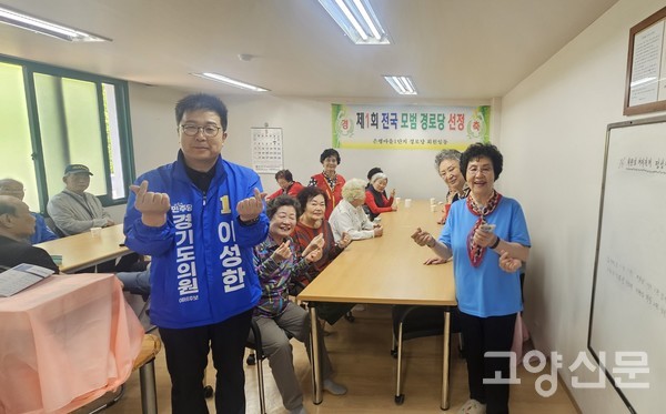 선거 기간 중 지역 경로당을 방문해 어르신들과 함께 환하게 웃으며 기념촬영을 하고 있다.