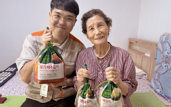 일산종합사회복지관 사회복지사(왼쪽)가 어르신에게 김치를 전달하고 있다.