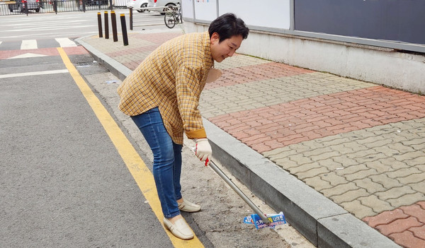 거리에 떨어진 휴지를 줍고 있는 김수진 당선인