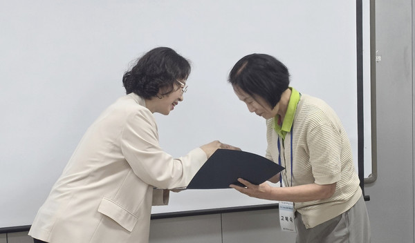 최윤정 관장이 한 참여자에게 수료증을 전달했다.