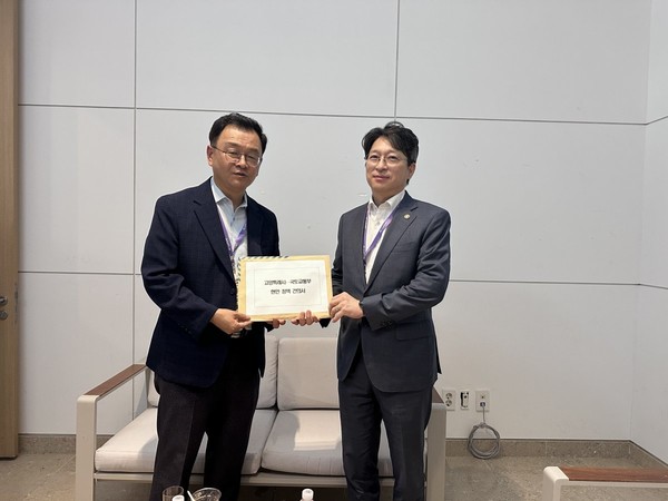 민경선 고양시장(왼쪽)이 29일 제주에서 홍지선 국토교통부 제2차관을 만나 '고양은평선 일산 연장' 등 지역 광역교통 현안이 담긴 정책 건의서를 전달하고 있다. 고양시 제공.
