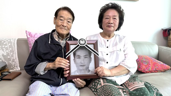 박옥삼 최숙자씨 부부가 폐질환으로 숨진 최씨의 남동생 영정 사진을 들고 있다.