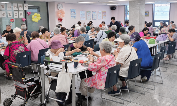 어르신들이 흰돌종합사회복지관에서 삼계탕으로 식사를 하고 있다.(일부 얼굴 이미지 AI활용)