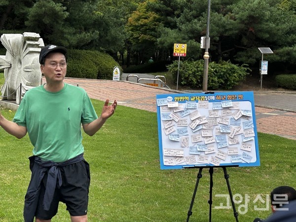 안민석 교육감이 잔디광장에 마련된 '안민석 교육감님께 하고 싶은 말'이라는 소통 패널 앞에 서서 시민들이 남긴 포스트잇 메모에 대해 답변을 하고 있다.