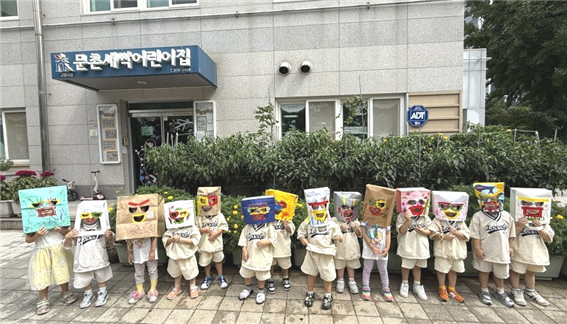  어린이들이 작은도서관에서 『나는 괴물이다』를 본 뒤, 책 속 장면을 따라 봉투를 머리에 쓰고 함께했다.