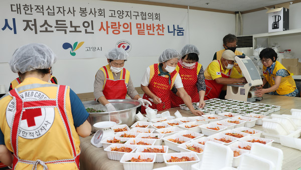 적십자 회원들이 반찬을 용기에 담고 있다. 전현직 회장들과 회원들이 함께 했다.