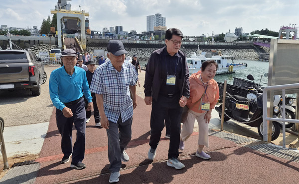 심은보 조합장이 원로조합원의 손을 잡고 연안부두를 이동하고 있다.