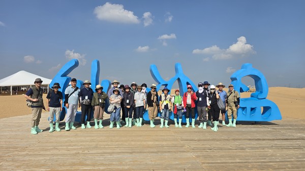 고양신문여행학교 회원들이 신발 위에 긴 양말을 신고 사막을 체험하고 있다.