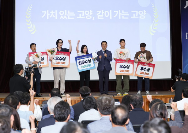 현장 투표를 통해 시정슬로건이 최종 확정된 후, 민경선 시장(가운데)이 입상자들과 함께 단상에 올라 기념촬영을 하고 있다. 스크린에는 최종 선정된 '가치 있는 고양, 같이 가는 고양'이 띄워져 있다.
