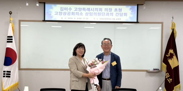 이상헌 고양상공회의소 회장(오른쪽)이 김미수 고양시의회 의장에게 꽃다발을 건네며 기념 촬영을 하고 있다. 고양상공회의소 제공