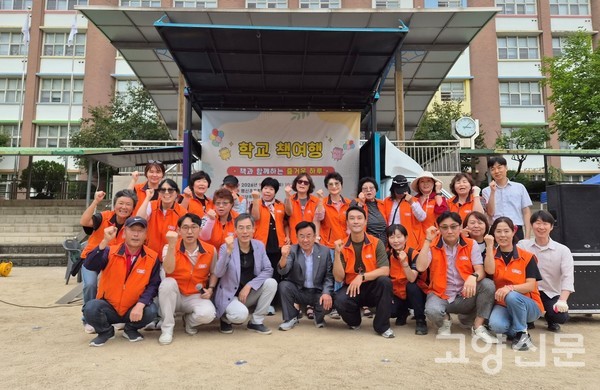 지난 12일 행신초등학교에서 열린 '행신 숲속 책 여행' 행사를 주관한 행신1동 주민자치회와 관계자들이 행사 무대 앞에서 단체 기념 사진을 촬영하고 있다.