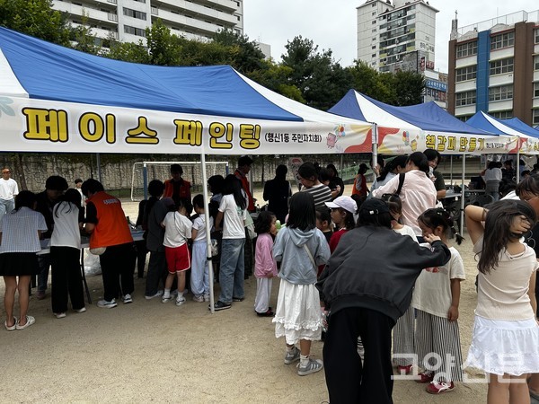 어린이 참가자들이 페이스페인팅 부스 앞에서 체험을 위해 순서를 기다리고 있다.