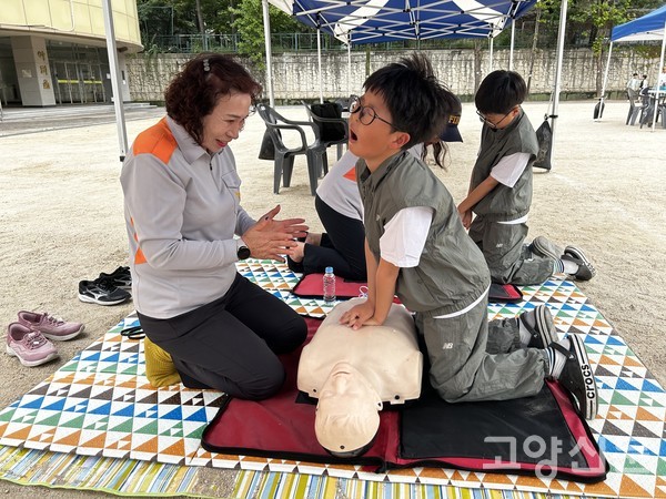 고양소방서 의용소방대원의 안내에 따라 어린이 참가자가 실습용 마네킹을 활용해 심폐소생술(CPR)을 체험하고 있다.