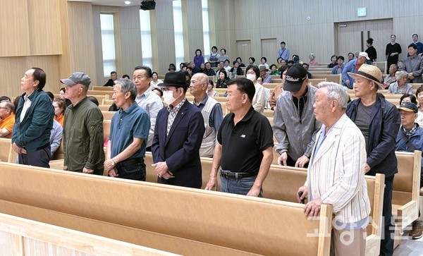 지축 간이 상수도 대의원들과 원주민 대표들이 자리에서 일어나 참석자들을 향해 인사하고 있다.