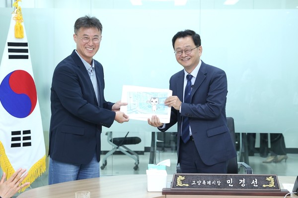 민경선 시장이 항공우주기업 ㈜모멘텀스페이스 전동익 대표이사(왼쪽)로부터 관련 정책 자료를 전달받고 있다. 고양시 제공.
