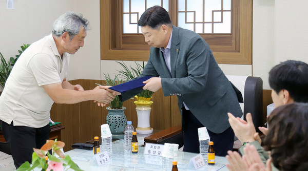 홍성규 조합장(오른쪽)이 대학생 자녀를 둔 조합원에게 장학금을 전달하며 격려하고 있다.