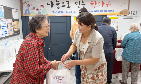  백미경 관장(오른쪽)이 한 어르신에게 꾸러미를 전달하고 있다.
