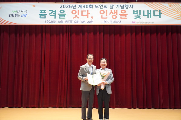  장기욱 일산노인종합복지관장(왼쪽)이 공모작품 시상식을 하고 있다.