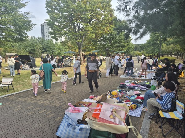 가족 단위 방문객들이 돗자리를 펴고 헌옷과 장난감 등을 교환 및 판매하는 어린이 벼룩시장 전경. 창릉동 주민자치회 제공
