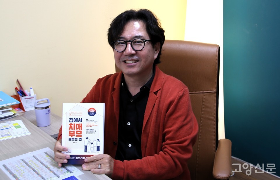 현장의 치매 돌봄 지침을 담은 신간 『집에서 치매 부모 돌보는 법』을 들어 보이고 있는 박창훈 연세케어센터 요양원 대표원장.