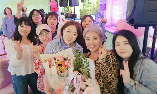 첫 팬미팅을 하며 팬들과 기념사진을 찍는 가수 유경(오른쪽 두 번째).