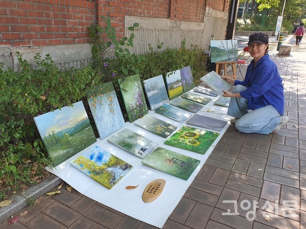 자연 풍경을 나무판에 담는 이정임 작가가 자신의 작품을 소개하고 있다.