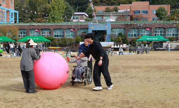  공굴리기를 하며 즐거워하는 참여자들과 학생.